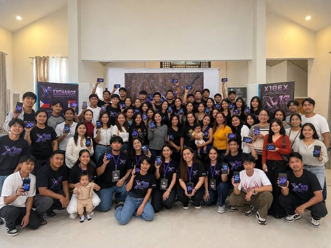 A large group of Filipino participants pose together, many holding up branded “X18EX” cards at the X18EX AI Orientation & Awareness Program, celebrating learning and participation in AI, blockchain, and Web3 innovation. The backdrop also displays the “X18EX” ticker and “Exchange” branding.