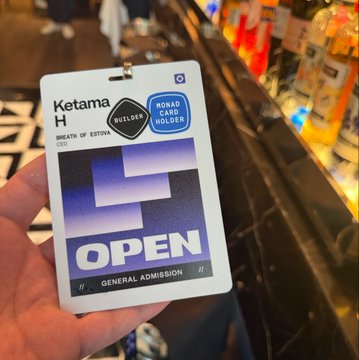 A hand holding a 'Ketama H' event badge marked as Builder, Road Core Holder, with Open General Admission access, at what appears to be a bar or venue.