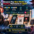 An advertisement for Binance Pay showing it 'Now Works at PayPay Merchants in Japan,' featuring a smartphone displaying a payment interface and logos for Binance Pay and PayPay.