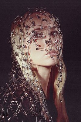 The image features a striking portrait of a woman wearing an elaborate web of metal armor-like mesh over her head and shoulders, set against a dark background. This artwork, titled "Metal Armor" by @natariaaa, aligns with the post announcing its collection on @objktcom, visually capturing the metallic, sculptural theme suggested by the title.
