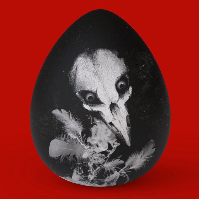 A black egg with a haunting white skull or bird-skull face design and floating feathers, photographed against a vivid red background.