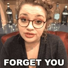 The image features a woman wearing glasses sitting next to a wine rack filled with bottles. The caption reads "Forget You", which seems to be a reference to the consolidation effort of the Hedera Foundation/HBAR Inc, as indicated by the text in the image.