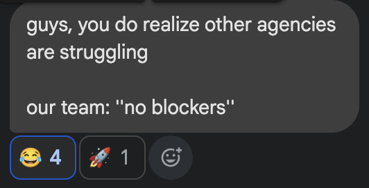 A Slack message reads "guys, you do realize other agencies are struggling / our team: 'no blockers'" with 4 laughing reactions and 1 rocket emoji, humorously highlighting the team's standout success compared to industry struggles. This ties into the post celebrating their record-breaking July performance and upcoming big sales announcement, suggesting their team is firing on all cylinders without obstacles.
