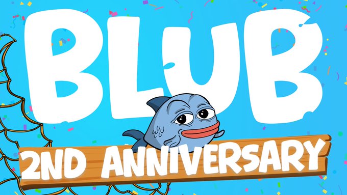 Celebratory graphic announcing "BLUB 2ND ANNIVERSARY" in bold white letters on a bright blue background, featuring a smiling cartoon blue shark holding a wooden sign that reads "2ND ANNIVERSARY," with confetti and fish hook illustrations — matching the post's milestone celebration and the drop of 50 new $BLUB Originals NFTs.