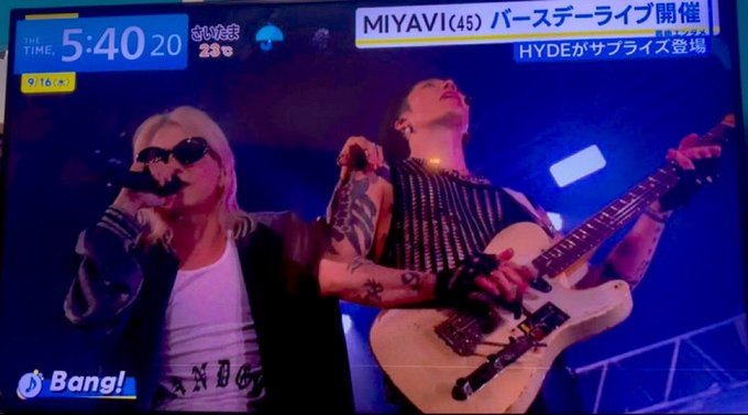 A television broadcast showing two rock musicians performing on stage, with text overlays reading 'MIYAVI(45) バースデーライブ開催', 'HYDEがサプライズ登場', and a 'Bang!' logo.