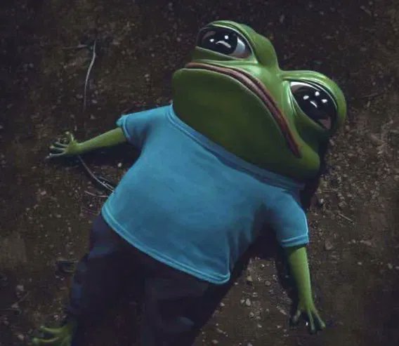 A stylized anthropomorphic green frog character with large expressive eyes lies on dark ground, wearing a blue t-shirt and dark pants in a melancholic pose.