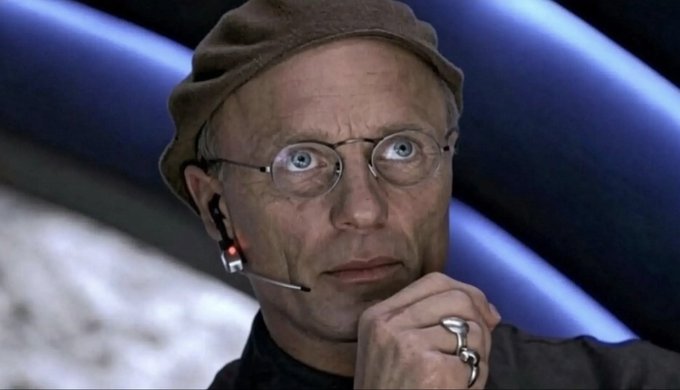 A man with glasses, a hat, and an earpiece is shown with wide eyes and his hand on his chin, suggesting a startled or amused reaction. The image fits the post's context of announcing that Vlad Tenev (commonly associated with the "Roaring Kitty" persona from WallStreetBets) follows the $WRESTLER account, capturing a look of surprise.
