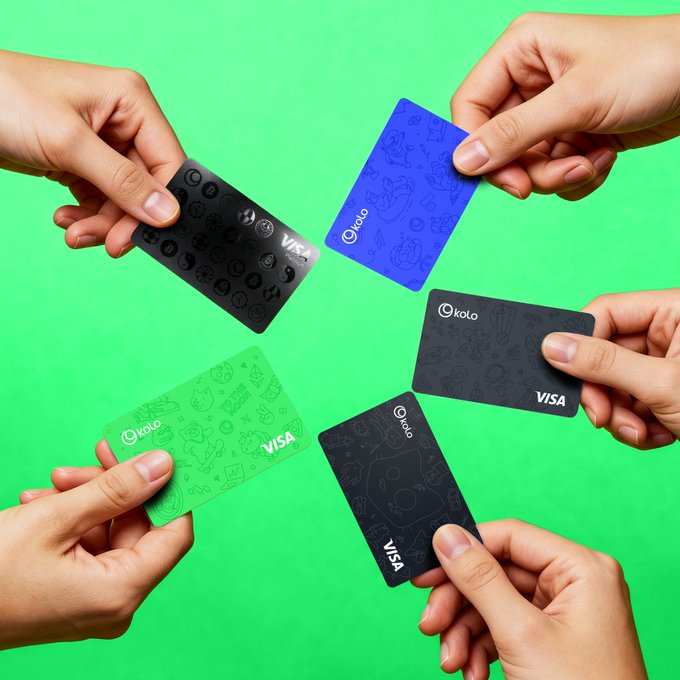 The image shows a group of people holding up five different Visa credit cards against a green background. The cards are arranged in a circle, with each card held by one person from the outer edge towards the center. The cards feature various designs and colors, showcasing the versatility and appeal of these payment methods. The post about KoloHub seems to be promoting the use of cryptocurrency for payments or transactions, as suggested by the image's context.