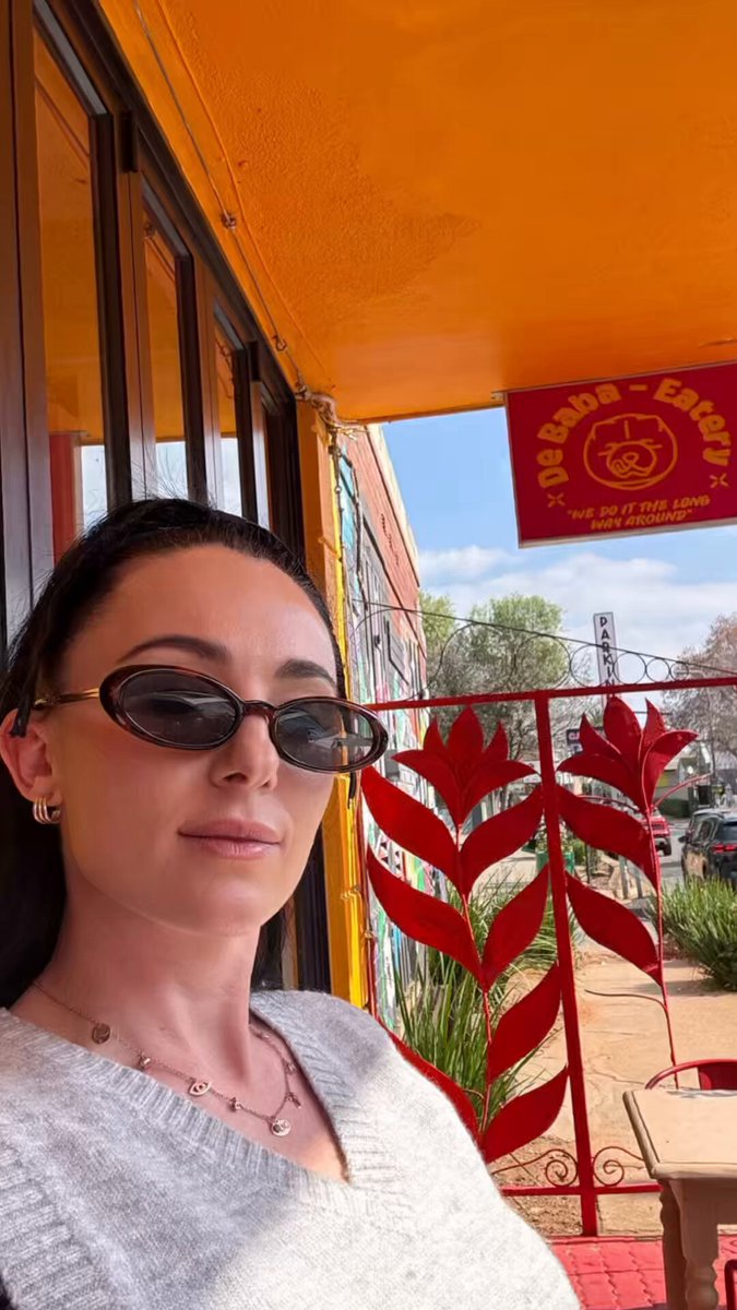 The image features a woman wearing sunglasses, standing next to a window with a red fence outside. The woman appears to be posing for a photo or taking a selfie. There are also some text elements in the image that seem to be related to a social media platform called "Gm South Africa". This post is about promoting a web3.bitget wallet and encouraging users to download it by offering a $100 chance of winning. The woman's sunglasses could be used as an accessory for this promotional photo, adding a stylish touch to the image.
