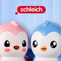 The image showcases two Schleich Pudgy Penguins figurines—one pink and one blue—displayed against a light blue background with the red "Schleich" logo visible at the top. The colorful penguin characters correspond to the new Pudgy Penguins x Schleich collaboration mentioned in the post.