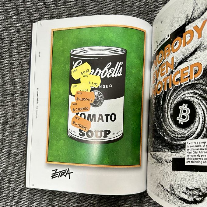 An open magazine spread features a green art print titled "TOMATO SOUP" (signed "ZETA") depicting a Campbell's soup can adorned with Bitcoin price tags ($0.48, $1.00, $1.25, $0.000112, $0.000005, ₿0.000002) from 2025-2030, alongside a black-and-white page showing a Bitcoin "₿" vortex with the headline "NOBODY EVEN NOTICED."