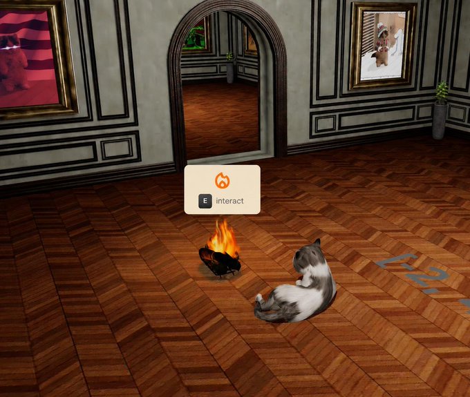 A screenshot from a first-person perspective video game showing a gray and white cat lying on a wooden herringbone floor next to a small fire, with an 'E interact' prompt displayed on screen.