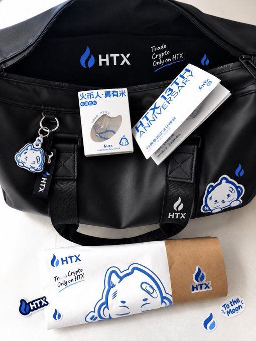 A black HTX branded bag with stickers and merchandise is displayed, featuring text including 'Trade Crypto Only on HTX,' a 13th anniversary flyer, and 'To the Moon' graphics.