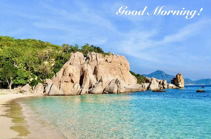 A scenic beach view with large granite boulders, turquoise water, and a 'Good Morning!' text overlay in the upper right corner.
