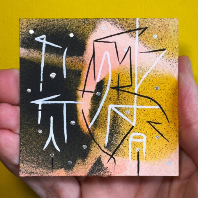 In the image, a person's hand is holding up a small square of paper with Chinese characters painted across its surface. The art style appears to be done using spray paint or chalk. This painting depicts an object like a bicycle or a bike tire, but without any people or text on it. The overall feel of the artwork seems abstract and artistic. The post mentions that the painting is from China and potentially worth collecting due to its uniqueness.