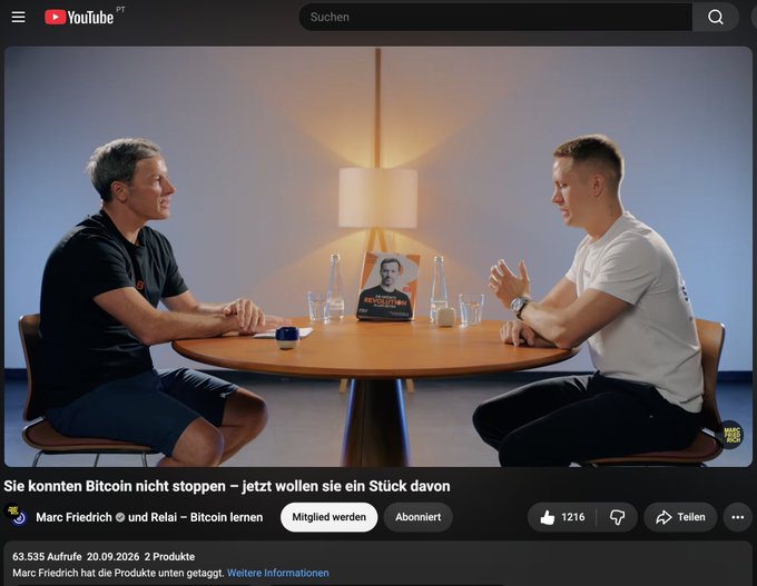A YouTube video screenshot showing two men seated at a table in conversation, with the title 'Sie konnten Bitcoin nicht stoppen – jetzt wollen sie ein Stück davon' by Marc Friedrich and Relai.