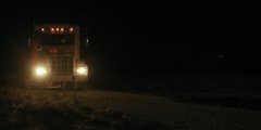 A dark, heavily motion-blurred night photo showing streaks of light, possibly a vehicle or streetlamp, with little discernible detail.