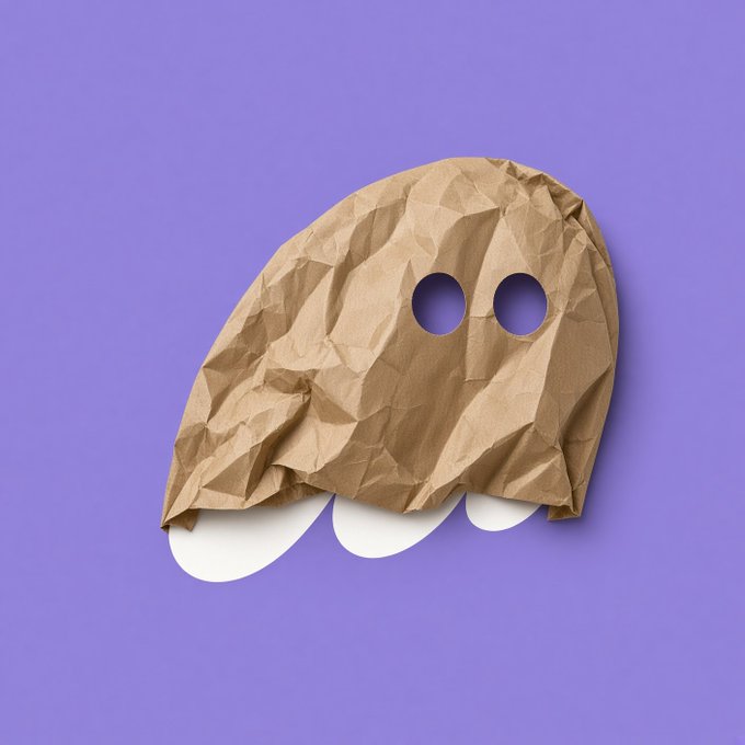 A 3D rendering of a ghost-like figure made from crumpled brown kraft paper with circular eye cutouts and rounded feet, set against a purple background.
