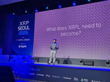 A presenter stands on stage at XRP Seoul 2026, delivering the keynote "Building XRPL for the Next Wave of Adoption" with the question "What does XRPL need to become?" displayed on the large screen behind him. The event, sponsored by Ripple and XRPL Korea, features speaker Ayo Akinyele, Senior Director of Engineering at Ripple, addressing what's being built into the XRP Ledger for future developers, institutions, and users.