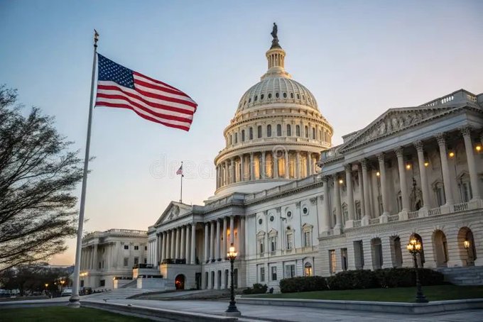 The United States Capitol building is shown at dusk with the American flag flying prominently in the foreground.