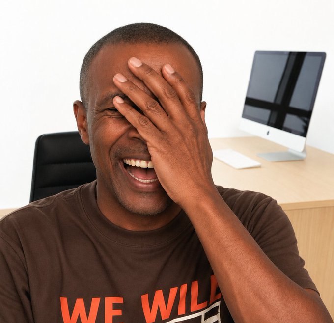 A man in a brown "WE WILL" t-shirt bursts into laughter while covering his face with his hand, seated in front of a desk with an Apple computer. The image perfectly captures the shared humor of the caption's Pidgin English joke about people finally rushing to turn off notifications ("Notis for Notis") to find some peace.