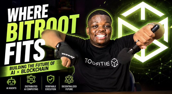 A young man wearing a black "TOOGSITIE" t-shirt smiles while holding a microphone, set against a vibrant green digital backdrop featuring the text "WHERE BITROOT FITS — BUILDING THE FUTURE OF AI × BLOCKCHAIN" alongside a glowing 3D cube logo. Four icons at the bottom highlight the project's pillars: AI Agents, Distributed AI Computing, Verifiable Execution, and Decentralized Future, visually reinforcing the post's emphasis on Bitroot's role at the intersection of AI and blockchain.