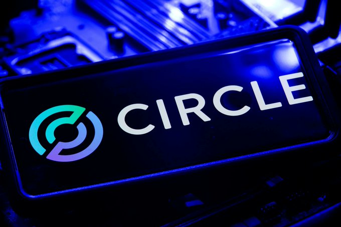 The image displays the Circle logo and name on a smartphone screen set against a blue-lit circuit board background, visually representing the company's technology-driven role in the digital finance sector. This relates to the post by highlighting Circle's USDC stablecoin and its new institutional partnership with Standard Chartered for issuance and redemption services.
