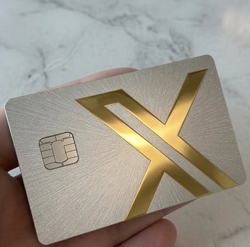 A hand holds a premium silver and gold metal card featuring a prominent gold "X" logo and an embedded EMV chip, branded as "XMoney." The luxurious finish and sleek design match the post's boast about its high-end texture and increased investment interest rate, suggesting it functions as a premium financial or digital asset card.