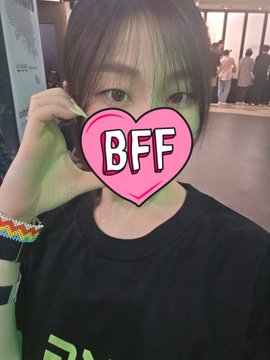 The image features a person wearing a black shirt with a pink heart-shaped sticker that says "BFF" written above their name. The person appears to be posing for a photo or selfie, possibly at an event like a meetup where they were able to take this picture.