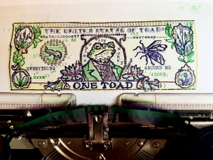 A novelty 'One Toad' bill reading 'THE UNITED STATES OF TOADS' with various toad-themed designs, being printed by an old typewriter.