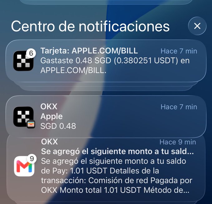 A mobile notification center in Spanish shows three alerts: a card transaction on APPLE.COM/BILL for 0.48 SGD, a payment notification for Apple via OKX, and a Gmail notification detailing a deposit of 1.01 USDT into a Pay balance via OKX.