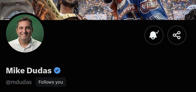 The image shows a social media profile of Mike Dudas (@mdudas), featuring his photo and a banner of what appears to be a sports celebration with confetti and championship belts. This relates to the post where the author expresses surprise and gratitude for being followed by Dudas, an influential figure in the crypto/tech space, while promoting the Solana-based $TOAD project.