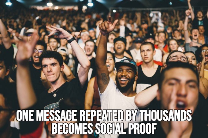 The image shows a large crowd of people gathered together for an event or concert. The text at the bottom of the image reads "One message repeated by thousands becomes social proof", which suggests that the popularity of this particular message has been amplified through the sheer number of times it has been shared and discussed on social media platforms, thus becoming a widely recognized and accepted piece of information within the online community.