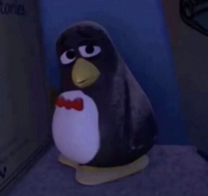 A small penguin figurine wearing a red bowtie sits in a dimly lit corner, looking dejected. The image's gloomy, isolated mood mirrors the post's mockery of someone giving back to a community that supposedly wasn't there when they needed $25k out of $30k.
