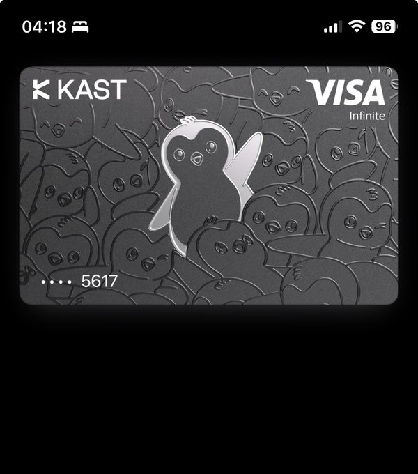 A digital representation of a KAST Visa Infinite card displayed on an iPhone screen, featuring a metallic finish with embossed penguin illustrations and the card number ending in 5617. The image relates to the post by showcasing the user's upgraded KAST card, highlighting the premium tier design they prefer over the standard option mentioned in their comment.