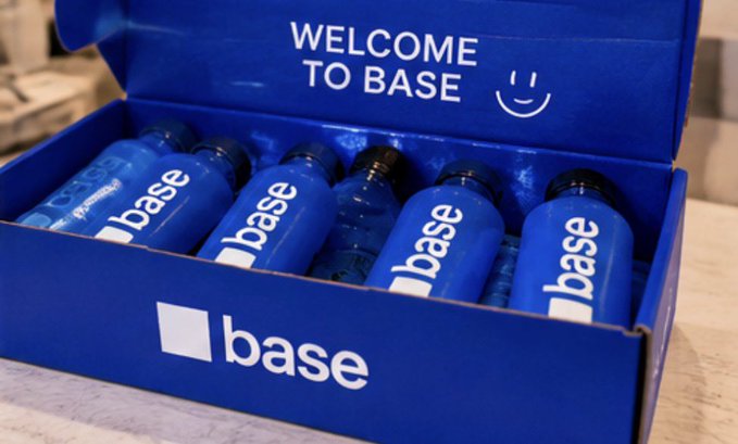 An open blue box labeled 'WELCOME TO BASE' with a smiley face contains several blue water bottles branded with the 'base' logo.
