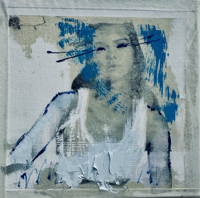 An abstract mixed-media artwork featuring an ethereal figure rendered in shades of blue, white, and gray on textured canvas with dripping paint effects.