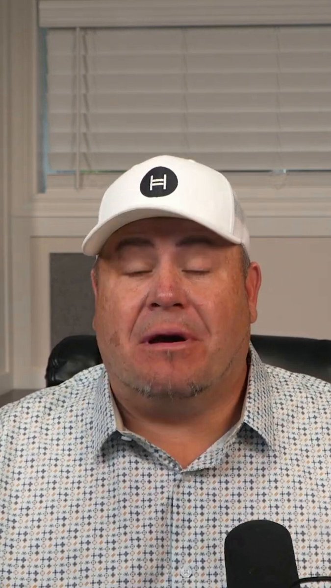 The image features an older man wearing a white baseball cap, sitting at a desk with his eyes closed. The caption of the image reads "They are shaking the markets before entering a NEW WORLD ORDER. The dollar is weakening $XRP and digital assets will be a big part of this. I explain here how Mark Carney spent over a decade weakening the dollar from the inside."