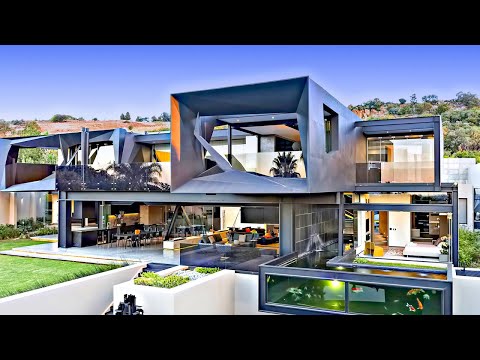 An exterior photograph of a luxurious, modern multi-story mansion with striking geometric architecture, large glass windows, and expansive outdoor living spaces surrounded by lush greenery.