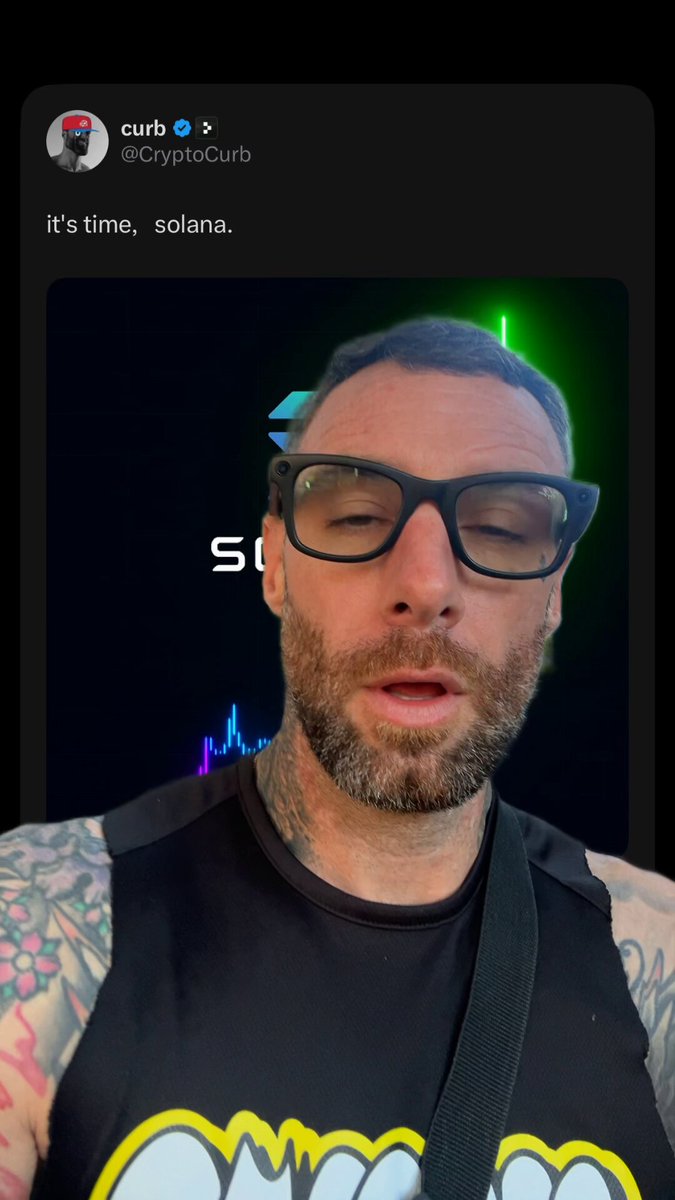 The image features a man wearing glasses, a black shirt with yellow text, and tattoos on his arms. He has a beard and appears to be looking at the camera. The caption of the image reads "I looked up Solana bull on google and found curbs pfp lol 9.0 for my guy". This suggests that the man is interested in cryptocurrency or blockchain technology, as he referred to it as "Solana bull" in his post.