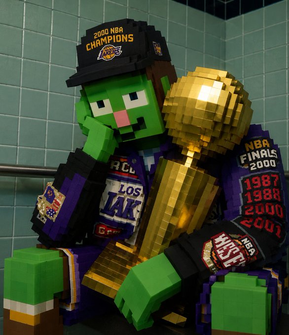 A 3D-rendered, blocky Minecraft-style zombie character wearing a purple Los Angeles Lakers jacket and a '2000 NBA CHAMPIONS' hat, sitting on a bench holding a golden NBA championship trophy.