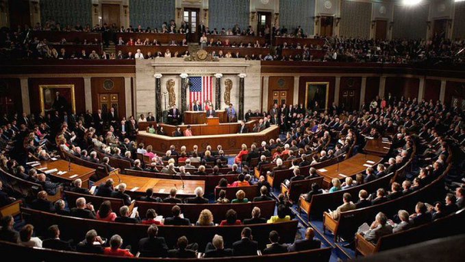 A crowded U.S. House of Representatives chamber filled with members and spectators during a joint session of Congress, with the American flag displayed at the front. The image pairs with the post about the Federal Reserve's $15 billion market injection, symbolizing the legislative backdrop behind the Fed's monetary actions that the post celebrates as the start of a "bull season."