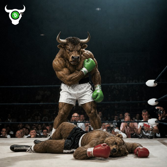 A surreal image of a muscular bull wearing green boxing gloves standing victorious in a boxing ring over a defeated bear in red gloves, featuring a bull head logo with a Bitcoin symbol in the corner.