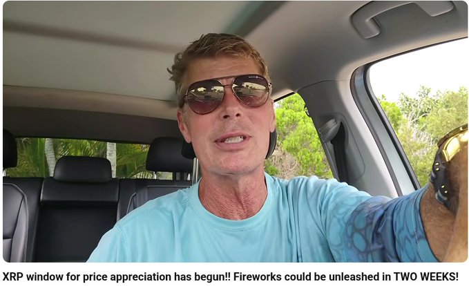 A man wearing aviator sunglasses and a light blue t-shirt speaks from inside a car, with text below reading 'XRP window for price appreciation has begun!! Fireworks could be unleashed in TWO WEEKS!'.