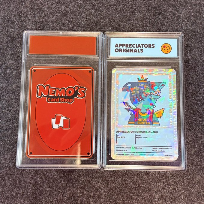 Two graded trading cards in protective cases: a red 'Nemo's Card Shop' card on the left and an 'Appreciators Originals #014' holographic card featuring a colorful shark character with 'HUNT 4 HUNTE' text on the right.