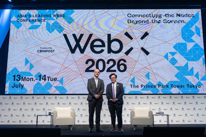 Two men in suits pose on stage at WebX 2026, Asia's leading Web3 conference held on July 13-14 at The Prince Park Tower Tokyo, with the event's banner reading "Connecting the Worlds Beyond the Screen" displayed on the large screen behind them. The image relates to the accompanying post by showing the speakers at the WebX 2026 conference during a session on Ethereum (ETH) and its institutional adoption.