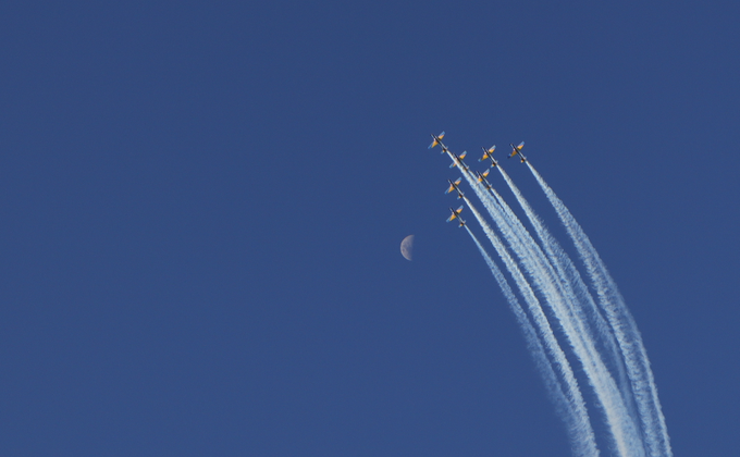 A formation of six jets ascends diagonally across a deep blue sky, leaving parallel white contrails with a small crescent moon visible to the left, symbolizing aspiration and the heights one can reach—mirroring the motivational message about seizing the chance to fly before the NFT edition sells out.