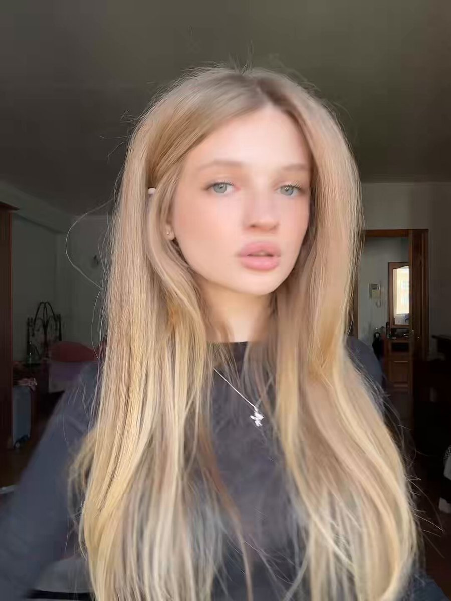 The image features a woman with long blonde hair wearing a black top, posing for a photo. She has her eyes closed and looks directly at the camera. The caption of the image includes the words "i definitely need more $HYPE". This suggests that the photo might be intended to generate interest or engagement from viewers by using humor in its description.