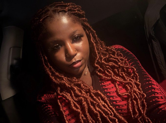 The image features a woman with long, red dreadlocks wearing a red shirt. She has her hair styled in an afro-like manner, giving her a unique appearance. The photo appears to be taken from behind her head or slightly to her side, providing a close-up view of the woman's face and hair.

The image also includes text that reads "gM Crypto Twitter we’ll do great things". This could potentially be a caption for the photo or an additional piece of information about the woman featured in the picture.