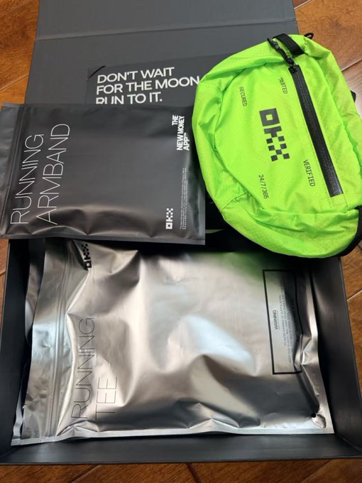 An unboxing photo showing a black box containing a 'RUNNING ARMBAND' package, a neon green fanny pack, and a 'RUNNING TEE' package, with text 'DON'T WAIT FOR THE MOON, RUN IN TO IT' on the box.
